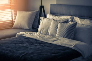 Güzellik odasında temiz beyaz yastıkları ve çarşafları olan yatak hizmetçisi. Yakın plan. Güneş ışığı altında mercek..