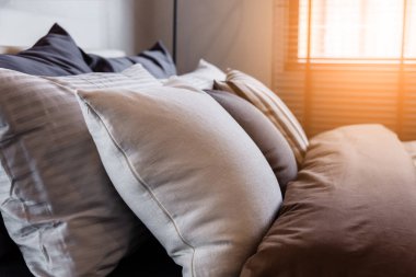 Yatak hizmetçi-up temiz beyaz yastıklar ve çarşaf güzellik yatak odasında. Yakın çekim. Objektif yetenek güneş ışığı altında.