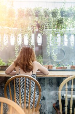 Güzellik Asyalı gril oturup tek başına kafede sezon yağmur olarak pencere bakarak üzgün ruh hali