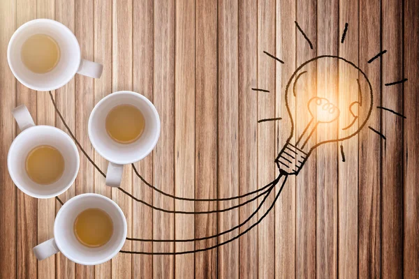 creativity ideas concept with glowing draw light bulb connect with ceramic glass od coffee on old plank wooden floor
