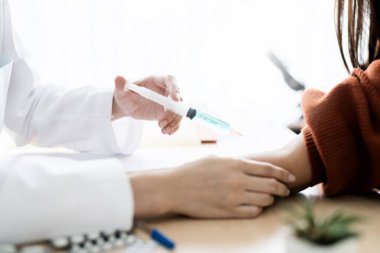 Asyalı doktor, Asyalı kadın hastalara muayene ve enjeksiyon serumu verdi.