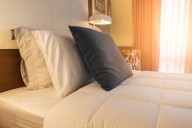 Yatak odasında temiz beyaz yastıkları ve çarşafları olan bir hizmetçi. Yakın plan. iç arkaplan