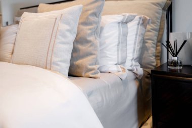 Yatak odasında temiz beyaz yastıkları ve çarşafları olan bir hizmetçi. Yakın plan. iç arkaplan