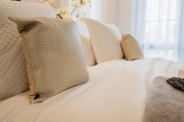 Yatak odasında temiz beyaz yastıkları ve çarşafları olan bir hizmetçi. Yakın plan. iç arkaplan