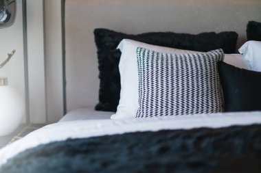 Yatak odasında temiz beyaz yastıkları ve çarşafları olan bir hizmetçi. Yakın plan. iç arkaplan