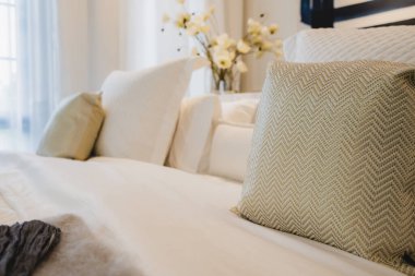 Yatak odasında temiz beyaz yastıkları ve çarşafları olan bir hizmetçi. Yakın plan. iç arkaplan