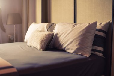 Yatak odasında temiz beyaz yastıkları ve çarşafları olan bir hizmetçi. Yakın plan. iç arkaplan