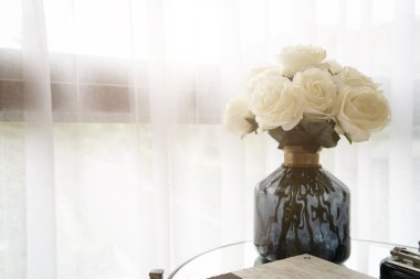 Güzel beyaz güller vazosu. Oturma odası arka planda.