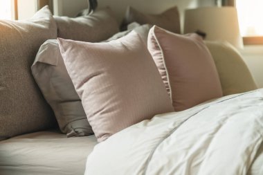 Yatak odasında temiz beyaz yastıkları ve çarşafları olan bir hizmetçi. Yakın plan. iç arkaplan