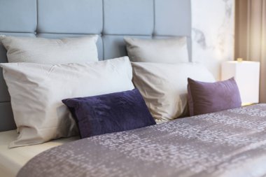 Yatak odasında temiz beyaz yastıkları ve çarşafları olan bir hizmetçi. Yakın plan. iç arkaplan