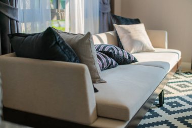 Güneşli bir günde kanepenin bir kısmıyla oturma odasının modern iç mekanı ve beyaz perde iç mekan konsepti