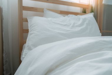 Yatak odasında temiz beyaz yastıkları ve çarşafları olan bir hizmetçi. Yakın plan. iç arkaplan