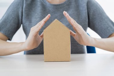 Asyalı kadın eli ile iş sigortası fikirleri kavramı ev kağıdı model beyaz arka planı korur