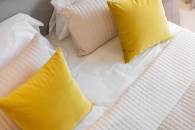 Yatak odasında temiz beyaz yastıkları ve çarşafları olan bir hizmetçi. Yakın plan. iç arkaplan