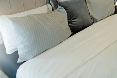 Yatak odasında temiz beyaz yastıkları ve çarşafları olan bir hizmetçi. Yakın plan. iç arkaplan