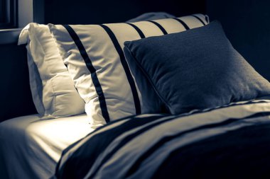 Yatak odasında temiz beyaz yastıkları ve çarşafları olan bir hizmetçi. Yakın plan. iç arkaplan