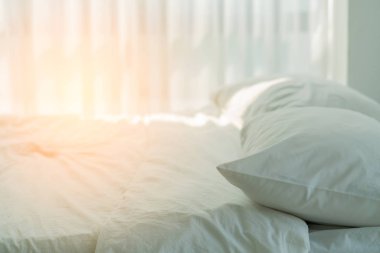 Yatak odasında temiz beyaz yastıkları ve çarşafları olan bir hizmetçi. Yakın plan. iç arkaplan