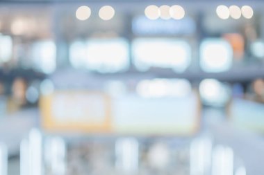 Alışveriş merkezinin arka planında yürüme yolu ve alışveriş yapan insanlar var.