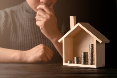 İşadamı eli ile iş kredisi finansal fikirleri ve ev ahşap model siyah arka planlı para yığını