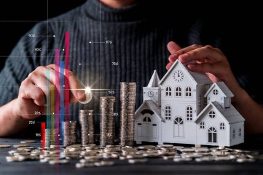 İşadamı eli ile iş kredisi finansal fikirleri ve ev ahşap model siyah arka planlı para yığını