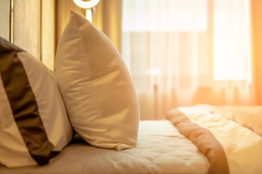 Yatak odasında temiz beyaz yastıkları ve çarşafları olan bir hizmetçi. Yakın plan. Güzellik odasında temiz beyaz yastıklar ve yatak çarşafları olan arka plan hizmetçisi. Yakın plan. iç arkaplan