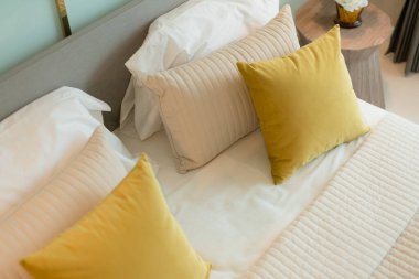 Yatak odasında temiz beyaz yastıkları ve çarşafları olan bir hizmetçi. Yakın plan. iç arkaplan