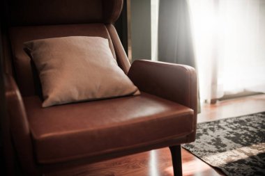 Beyaz yumuşak yastıklı deri koltuk ve beyaz perde arka planda ev arka planı