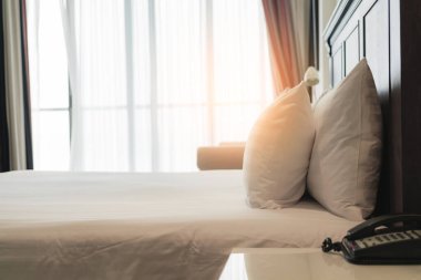 Yatak odasında temiz beyaz yastıkları ve çarşafları olan bir hizmetçi. Yakın plan. iç arkaplan