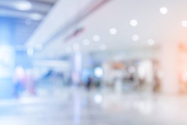 Alışveriş merkezinin arka planında yürüme yolu ve alışveriş yapan insanlar var.