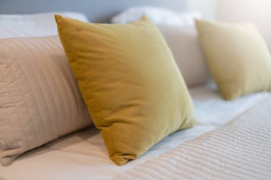 Yatak odasında temiz beyaz yastıkları ve çarşafları olan bir hizmetçi. Yakın plan. iç arkaplan