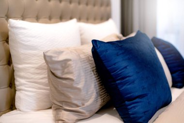 Yatak odasında temiz beyaz yastıkları ve çarşafları olan bir hizmetçi. Yakın plan. iç arkaplan