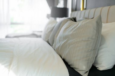 Yatak odasında temiz beyaz yastıkları ve çarşafları olan bir hizmetçi. Yakın plan. iç arkaplan