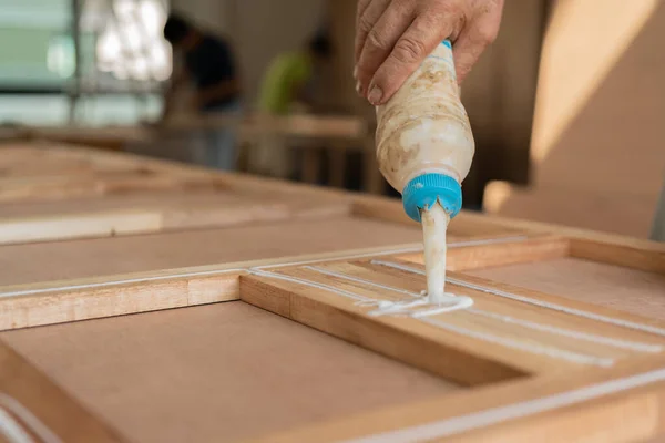 wood work carpenter concept with close up hand use glue for work