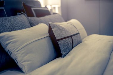 Yatak odasında temiz beyaz yastıkları ve çarşafları olan bir hizmetçi. Yakın plan. iç arkaplan