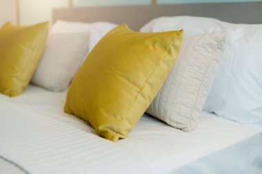 Yatak odasında temiz beyaz yastıkları ve çarşafları olan bir hizmetçi. Yakın plan. iç arkaplan