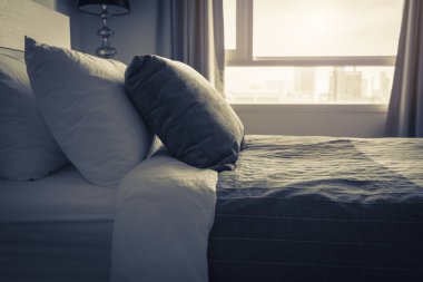 Yatak odasında temiz beyaz yastıkları ve çarşafları olan bir hizmetçi. Yakın plan. iç arkaplan