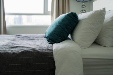 Yatak odasında temiz beyaz yastıkları ve çarşafları olan bir hizmetçi. Yakın plan. iç arkaplan