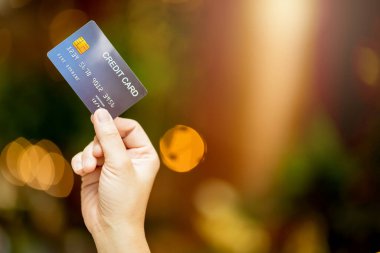 İş alışverişi tüccarı fikirleri soyut bir alışveriş merkezinin arka planına sahip alışveriş için kredi kartı tutan kadına yakın plan