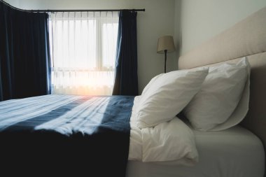 Yatak odasında temiz beyaz yastıkları ve çarşafları olan bir hizmetçi. Yakın plan. iç arkaplan