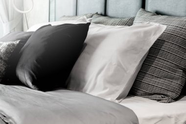 Çağdaş yatak odası tasarım konseptiyle beyaz rahat yataklı güzel yumuşak yastık ve battaniye.