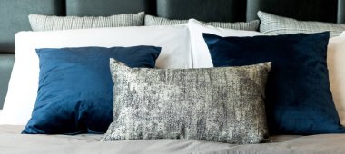 Çağdaş yatak odası tasarım konseptiyle beyaz rahat yataklı güzel yumuşak yastık ve battaniye.