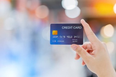 İş alışverişi tüccarı fikirleri soyut bir alışveriş merkezinin arka planına sahip alışveriş için kredi kartı tutan kadına yakın plan