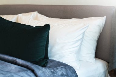 Yatak odasında temiz beyaz yastıkları ve çarşafları olan bir hizmetçi. Yakın plan. iç arkaplan