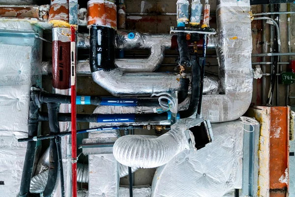 renovation underconstruction room with Electrical conduits system and metal pipeline installed on building ceiling Bare skin ceiling electrical wires in the sub ceiling in a massive wiring system on an unfinished construction site