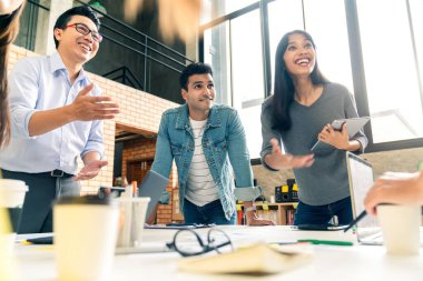 Bir grup iş arkadaşı gayri resmi bir toplantı yapıyor, iş adamları ofiste fikirleri tartışıyor.