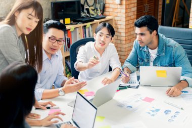 Bir grup iş arkadaşı gayri resmi bir toplantı yapıyor, iş adamları ofiste fikirleri tartışıyor.