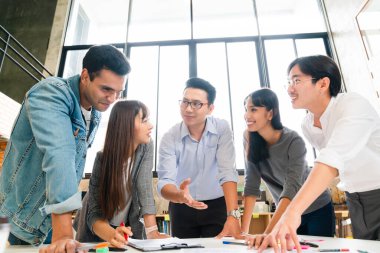 Başarılı iş adamları birlikte bir atölye beyin fırtınası yapıyorlar. Laptop kağıt belge tartışma ofisi geçmişini paylaşıyorlar.