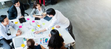 Mutlu iş adamı beyin fırtınası ve ofis sunumu sırasında beyaz masada tartışma.