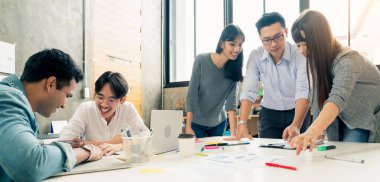 Bir grup iş arkadaşı gayri resmi bir toplantı yapıyor, iş adamları ofiste fikirleri tartışıyor.