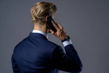 Kafkasyalı başarılı iş adamı sakallı, fare dudaklı, akıllı telefon gri arka planlı.